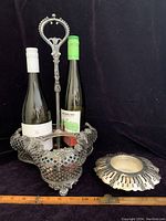Vintage silver-plated bottle holder holding two wine bottles, showing lattice craftsmanship and ornate central handle.