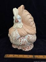 Full front view of the rooster cookie jar with a ruler to indicate size, showing textured feathers and peach colored body.