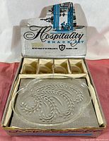 Photo of original box labeled 'Hospitality Snack Set' with four slots for cup and plate sets and one clear glass snack plate inside.