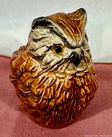 Front angled view showing detailed feather texture and coloring of the owl figurine.