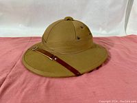 Front and right side view of the khaki Wolseley pattern pith helmet showing ventilation grommets, round crown, and leather strap detail on brim.
