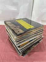 Side view of stacked vinyl LP record albums showing edges and album covers.