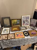 Full view of the assembled lot of various framed artwork of differing styles and sizes.