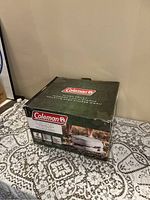 Box of Coleman flush toilet showing brand, product name, and product image