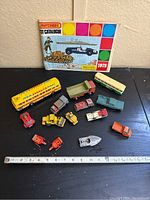 Overview of all items including catalogue, various vehicles and a measuring tape showing size.