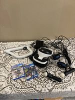 Full set laid out with VR headset, controllers, cables, and two game cases