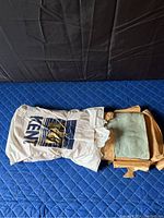 Image showing unopened plastic bag with vintage fabric bolt inside original paper packaging, fabric visible is light blue-green jacquard with floral motifs.