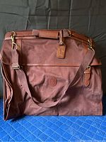 Front view of the large brown Ralph Lauren travel bag showing leather tag and side pockets.