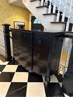 Angled front view of the dresser at bottom of stairs