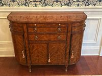 Front view showing two drawers over two cabinet doors with brass ring pulls and tassel keys