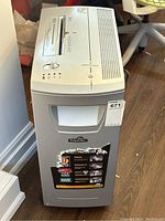 Front view of silver-gray Fellowes DM17Cs shredder showing branding, capacity sticker, waste bin handle and caster at base