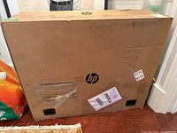 Front of sealed HP cardboard shipping box showing HP logo and intact packaging