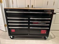 Front view of entire tool chest showing wood top, drawers, cabinet and caster wheels