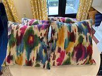 Four pillows arranged on round white table showing front abstract pattern.