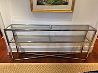 Front view of console table showing two-tier glass shelves and polished chrome frame