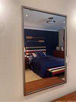 Front view of rectangular chrome framed wall mirror mounted on wall