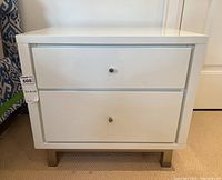 Front view showing two drawers, metal knobs and legs