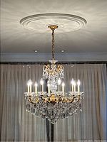 Full view of chandelier suspended from ceiling with lights illuminated