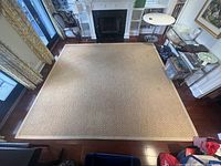 Full-room view of sisal carpet on hardwood floor under fireplace mantel.