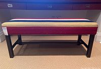 Front view of wood bench with striped upholstery