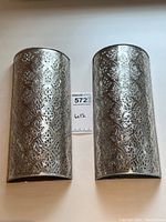 Front view of both tin wall sconces with measurement card showing size.