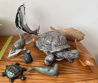 Photo of entire collection showing stone turtle, Blue Mountain Pottery turtle, glass dolphin, stone seals, and wooden fish