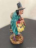 Front angle showing full figurine in green and yellow colorway, man holding pipe with masks attached to arm.