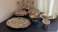 Full lot shown on table: pair of candelabras, meat carving tray, relish wagon, two covered dishes, pedestal plate, pedestal bowl.