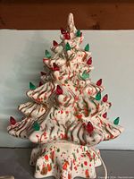 Front view of ceramic Christmas tree with red and green decorative bulbs, unlit