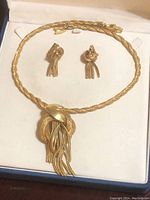 Overall view of vintage gold-tone necklace and matching clip-on earrings in lined jewelry box.