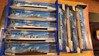 Eight boxed ships in original Hornby Minic Ships packaging, four horizontal Famous Liners and four upright Fighting Ships