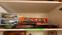Shelf with multiple HO scale train cars, boxes and strips