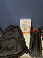 Black Roots backpack, MeatFreak retractable clothesline box, Backyard Grill adjustable iron grill.