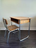 Side view of vintage school desk and chair showing chrome tubular steel frame and maple plywood surfaces.