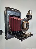 Kodak Eastman No.3 camera front angle showing red bellows, lens, shutter, and viewfinder.