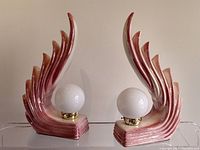 Front view of both lamps showing sculptural wave design and milk glass globes.