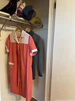 Photo of red and white polka dot maternity dress hanging in closet.