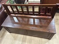 View of the wooden storage bench top and slatted backrest showing surface condition and structure.