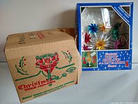 Photo showing vintage Christmas tree stand box with holiday graphics and text.