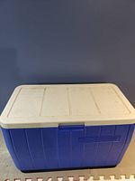 Photo of the closed blue plastic cooler with white lid and latch on front