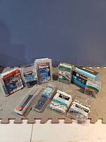 Photo showing the complete lot of fasteners including several boxes and plastic packaged screws and anchors on a grey mat against a blue background.