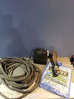 Rolled gasket material, electric heater, tarp packaging, metal clamp, tube of sealant on foam mat.