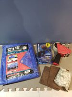 Photo showing whole lot items including blue tarp, tape dispenser, HDMI cables, wood blocks and hardware bag