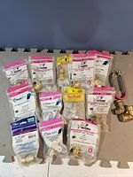 Multiple SharkBite plumbing fittings and accessories in original packaging and some loose fittings in lot.