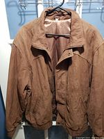 Front view of the brown suede jacket showing collar, snap button closure, and overall texture.