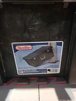 Photo of the Sterilite label showing product image, brand, and dimensions on the underside of the lid.