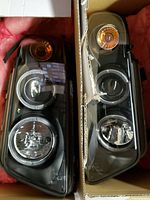 Pair of Audi A4 2000-2001 headlights side by side in cardboard box with pink padding.