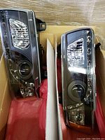 Pair of black clear headlights for BMW E36 2-door model side by side inside a box.