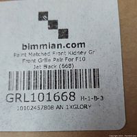 Close-up label showing bimmian.com branding and product details including model number GRL101668 and paint matched front kidney grille for F10 in jet black.