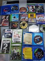 Photo showing full assortment of 21 games across PS4, PS5, Xbox 360, PS2, N64, and PC, including discs and cartridges laid flat.